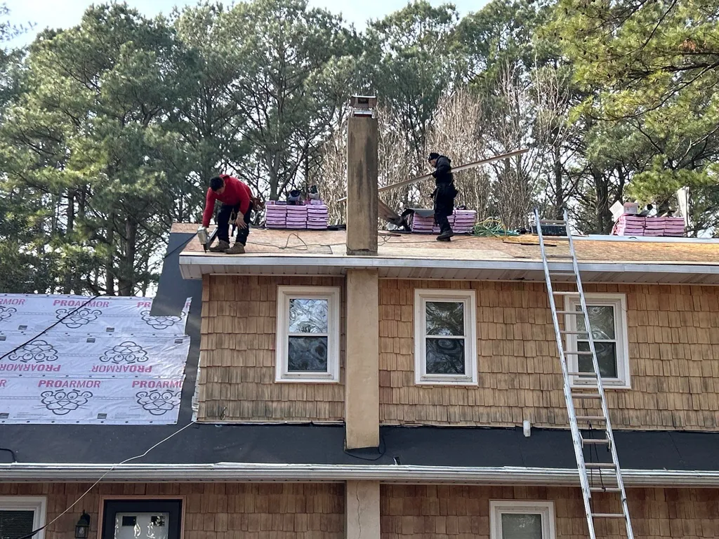 Precision Exteriors crew installing Owens Corning underlayment on a roof on Maryland's Eastern Shore
