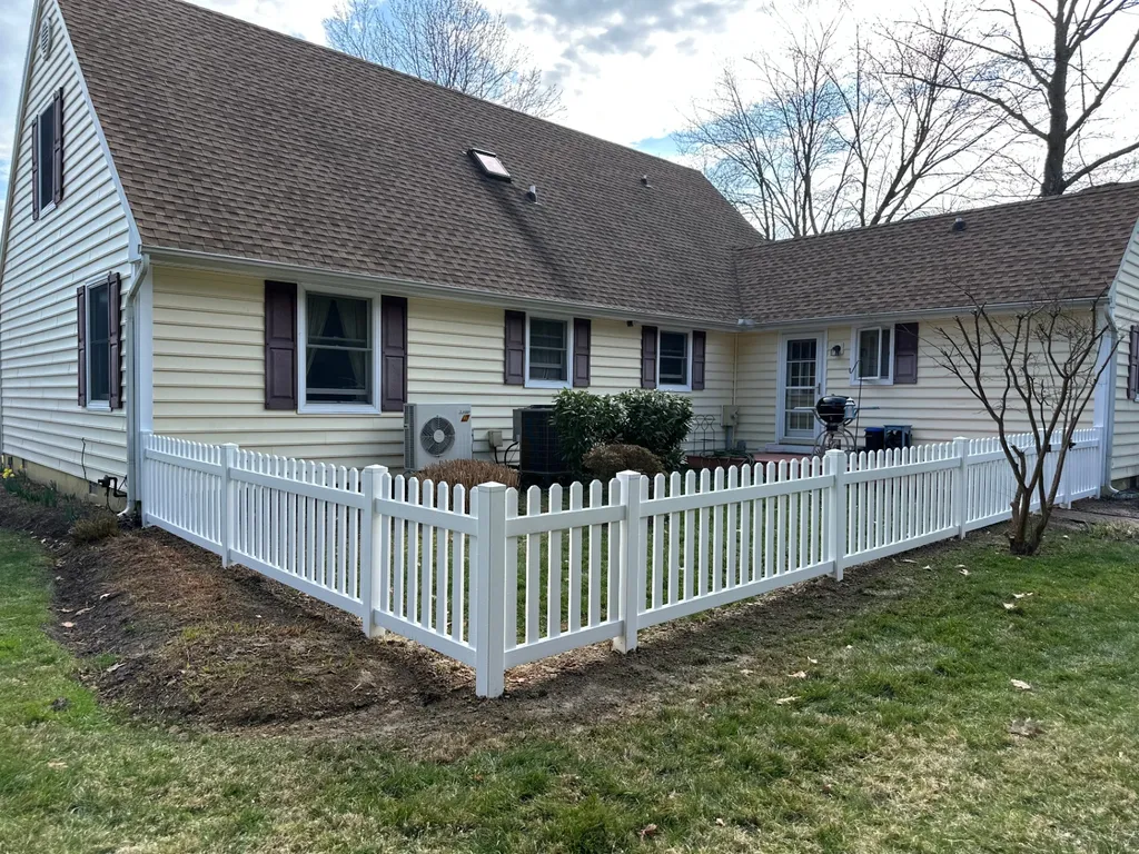 New white vinyl picket fence installed around a yard in St. Michaels, Maryland