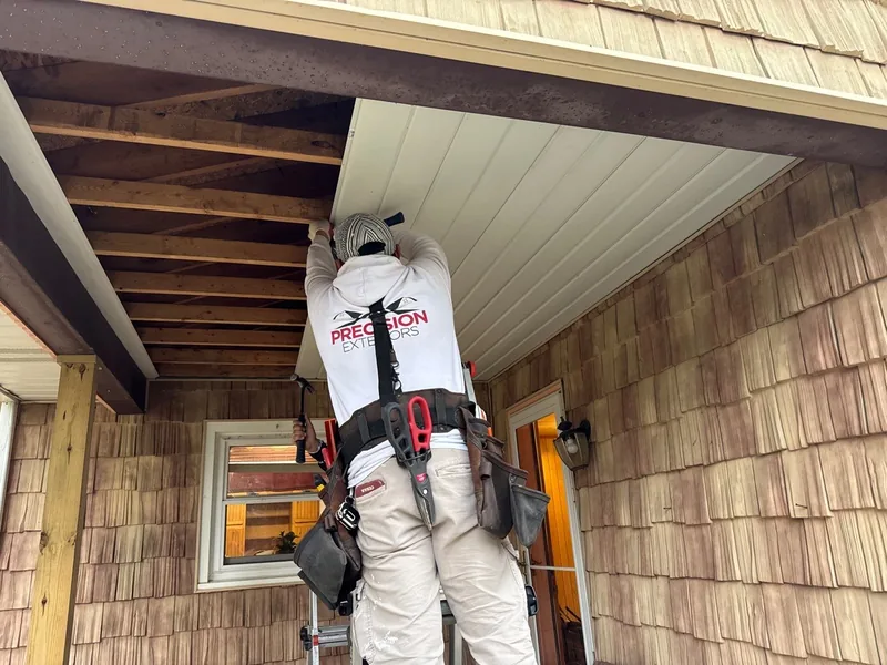 Precision Exteriors crew member installing new porch soffit